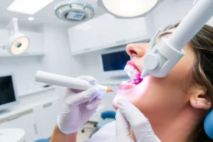 A modern dental clinic interior with a dentist examining a patient's teeth with advanced dental tools, showing close-up of a tooth with early cavity being treated using laser technology, clean white and blue color scheme, professional and calm atmosphere