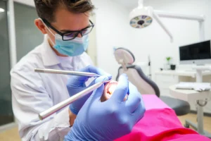 A dentist in a modern dental clinic treating a patient’s tooth, showing a close-up of a tooth with a cavity being filled, with dental instruments and a dental chair in the background, all in a clean, professional setting