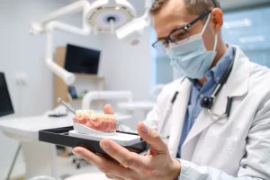 A professional dental clinic interior showing a dentist in a white coat examining a patient's dental implant model on a tray, with modern dental equipment, soft lighting, and a calm, sterile environment; focus on realistic details of dental tools and implant components, no text or symbols visible