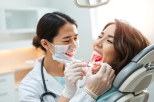A calm, modern dental clinic interior with a smiling dentist in a white coat gently placing a dental implant into a patient's mouth, soft natural lighting, realistic textures, no visible fear or pain on the patient's face, focus on trust and professionalism and advanced technology