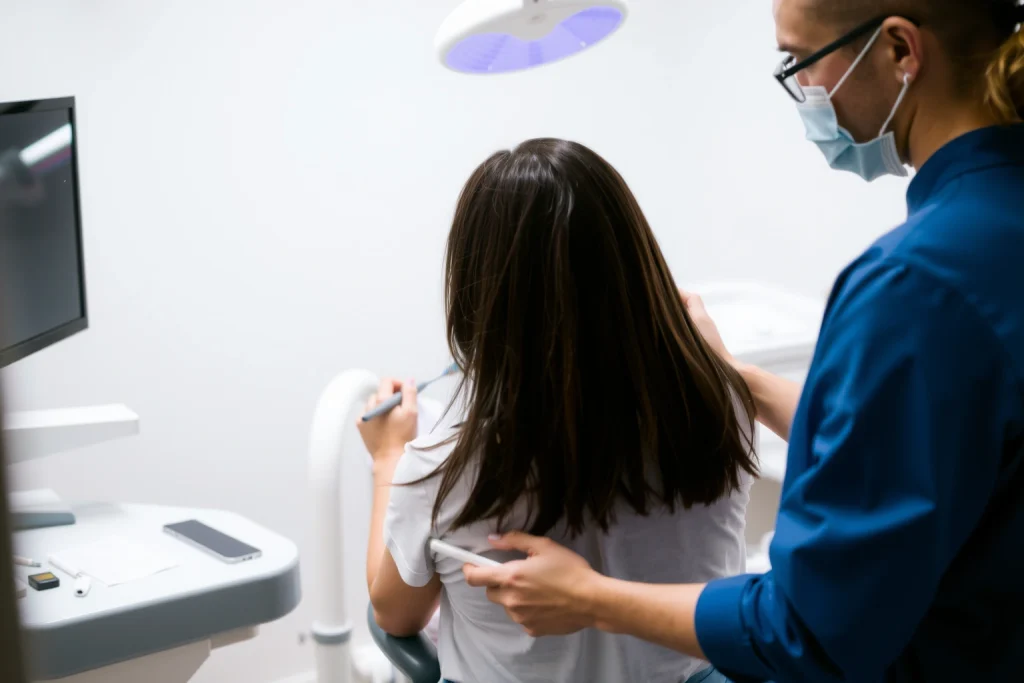 A calm dental clinic scene showing a patient sitting in a dental chair after periodontal treatment, with a dentist or hygienist gently explaining post-operative care instructions, including proper brushing technique and use of antiseptic mouthwash, soft lighting, clean modern environment, focus on patient education and recovery